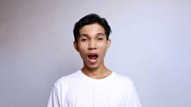 Beyaz tişört giyen Asyalı genç adamı kapat.