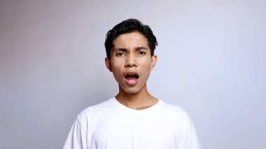 Beyaz tişört giyen Asyalı genç adamı kapat.