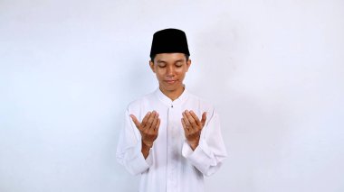 Yakışıklı Asyalı Müslüman gençler el kaldırıyor, beyaz arka planda dua ediyorlar.