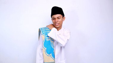 Genç Asyalı Müslüman adam, izole edilmiş beyaz arka planda kaşındıran bir vücudu kaşımak için el kol hareketi yapıyor.