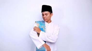 Genç Asyalı Müslüman adam, izole edilmiş beyaz arka planda kaşındıran bir vücudu kaşımak için el kol hareketi yapıyor.