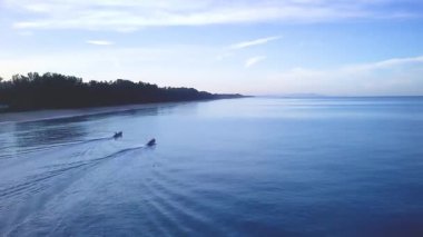 Drone Aerial of Long Tail Fishing Boats heading out at Dawn in Thai Muang, Phang Nga, Thailand in 4K.