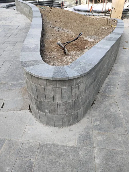 outdoor planter box area, with natural stone finishing and cable installation for garden lights.