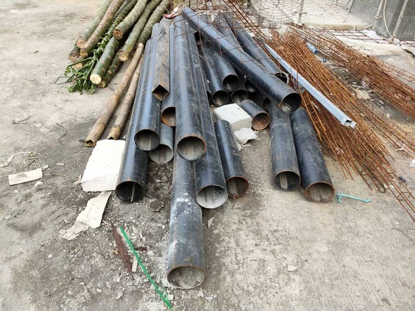 pile of black iron pipes in a building project.