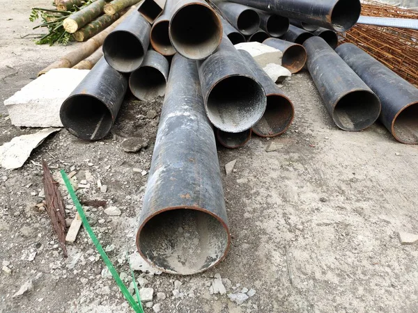 pile of black iron pipes in a building project.