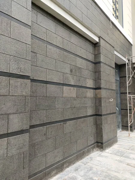 installation of natural stone tiles with finishing coating on building walls.