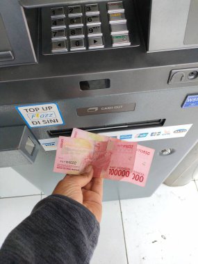 withdraw cash at an ATM machine. Bali - Indonesia ; January 1, 2023.