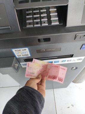 withdraw cash at an ATM machine. Bali - Indonesia ; January 1, 2023.