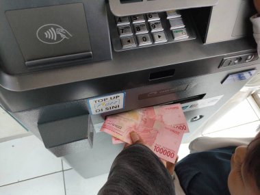 withdraw cash at an ATM machine. Bali - Indonesia ; January 1, 2023.