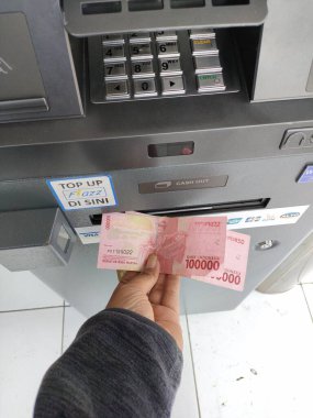 withdraw cash at an ATM machine. Bali - Indonesia ; January 1, 2023.