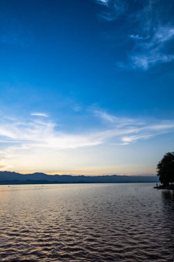 View of the lake and mountains during sunset at Kwan Phayao, Thailand.
