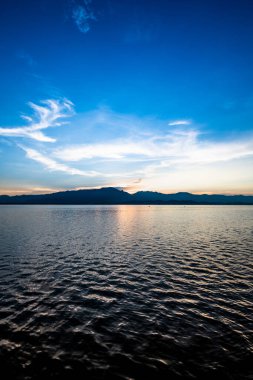 View of the lake and mountains during sunset at Kwan Phayao, Thailand.