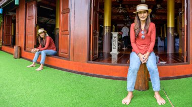 Pamorama of twin Asian women with old building background at Phayao province, Thailand.