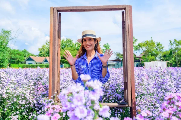 Thai Woman in Frame with Beautiful Flower Garden at Chiang Mai Province, Thailand.