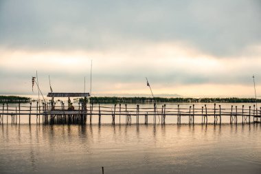 Small wooden bridge with Kwan Phayao lake at sunrise, Thailand.