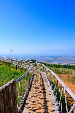 Wooden bridge with mountain view at Doi Sa Ngo viewpoint, Chiang Rai province.