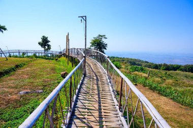 Wooden bridge with mountain view at Doi Sa Ngo viewpoint, Chiang Rai province.