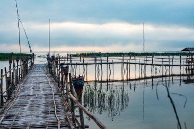 Small wooden bridge with Kwan Phayao lake at sunrise, Thailand.