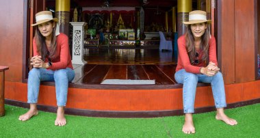 Pamorama of twin Asian women with old building background at Phayao province, Thailand.