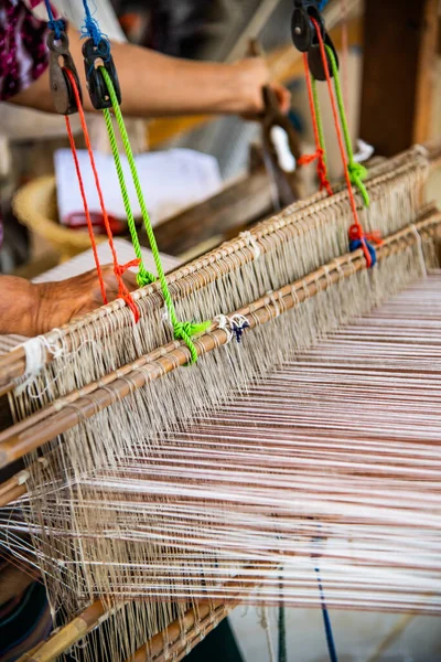 Native thread on Thai traditional weaving machine, Thailand.
