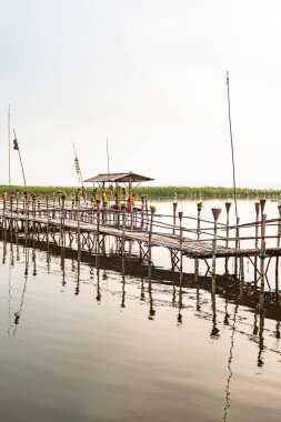 Small wooden bridge with Kwan Phayao lake at sunrise, Thailand.