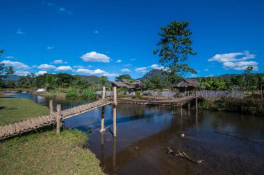 Tayland 'ın Chiangmai bölgesindeki Mueang Khong bölgesinde küçük kanalı olan bambu köprüsü..