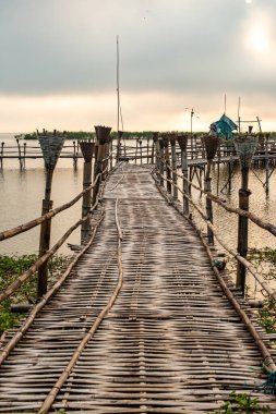 Small wooden bridge with Kwan Phayao lake at sunrise, Thailand.