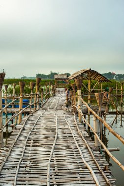 Small wooden bridge with Kwan Phayao lake at sunrise, Thailand.