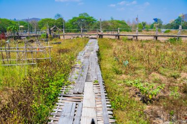 The wooden bridge with rice field at Phrathat San Don temple, Lampang province.