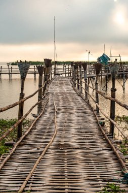 Small wooden bridge with Kwan Phayao lake at sunrise, Thailand.