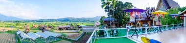 NAN, THAILAND - November 4, 2020 : Panorama View of Thai Style Building and Rice Fied at Si Mongkol Temple, Nan Province.