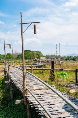 The wooden bridge with rice field at Phrathat San Don temple, Lampang province.