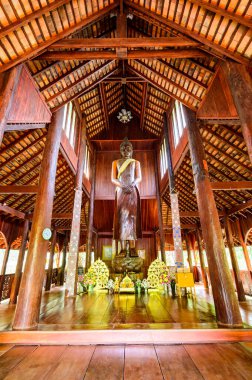 CHIANG MAI, THAILAND - March 21, 2021 : The Wooden Standing Buddha of Wat Luang Khun Win in Chiangmai Province, Thailand.