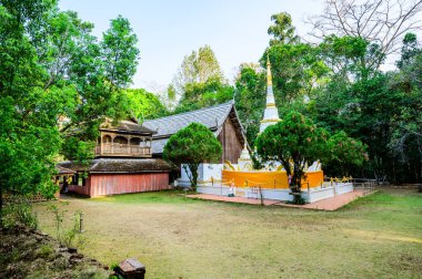 White Pagoda and Ancient Wooden Building of Wat Luang Khun Win in Chiangmai Province, Thailand.