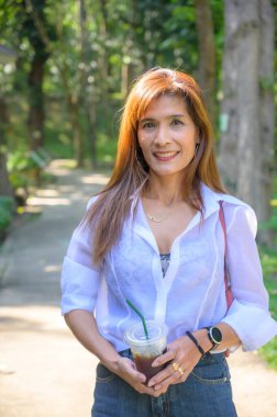 Asian woman wearing white shirt in the park, Chiang Mai Province.