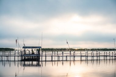 Small wooden bridge with Kwan Phayao lake at sunrise, Thailand.