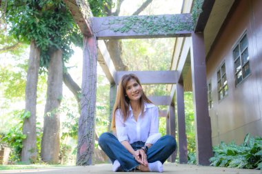 Asian woman wearing white shirt in the park, Chiang Mai Province.