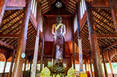 CHIANG MAI, THAILAND - March 21, 2021 : The Wooden Standing Buddha of Wat Luang Khun Win in Chiangmai Province, Thailand.