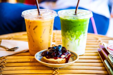 Buzlu Matcha Latte ve buzlu kahve ile yaban mersinli cheesecake, Tayland.