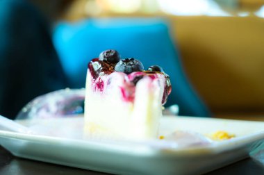 Kahve dükkanında beyaz tabakta yaban mersinli kek