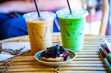 Buzlu Matcha Latte ve buzlu kahve ile yaban mersinli cheesecake, Tayland.