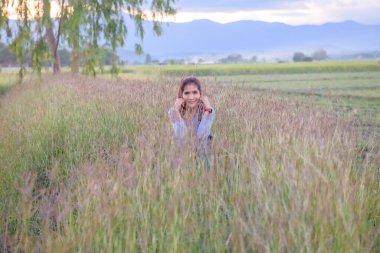 A woman is sitting in the rice field, Phayao province.