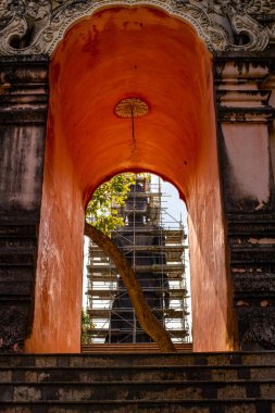 Big Standing Buddha under renovation with door frame in  Analyo Thipayaram temple, Thailand.