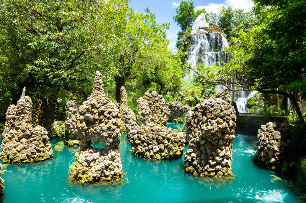 Зеленый водоем с водопадом в тенистом саду, Чиангмай провинции.