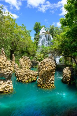 Green water pond with waterfall in a shady garden, Chiang Mai Province. clipart