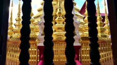 Wat Phan Tao, Chiang Mai vilayetindeki eski pencerenin ahşap parmaklıklarından antik altın pagoda manzarası.