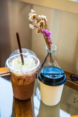 Plastik bardakta buzlu kakao ve Tayland Kağıt Kupada sıcak kahve..