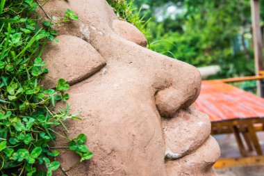 Kafasında çimen olan seramik bebek, Tayland.