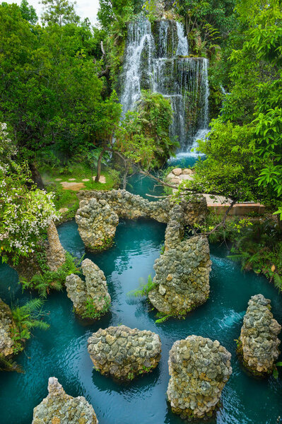 Водопад и зеленый пруд в тенистом саду, провинция Чиангмай.