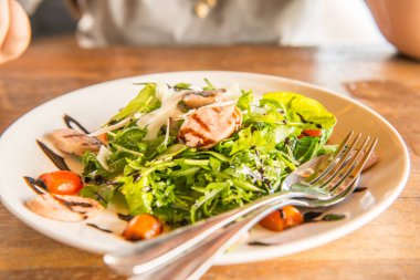 Beyaz tabak üzerinde İtalyan sosisi ve roket salatası, Tayland.